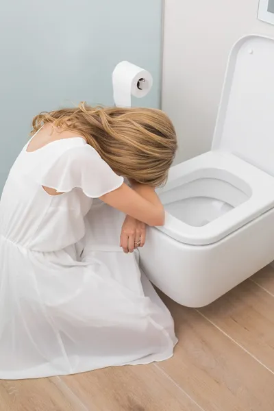 Kranke junge Frau sitzt auf der Toilette — Stockfoto