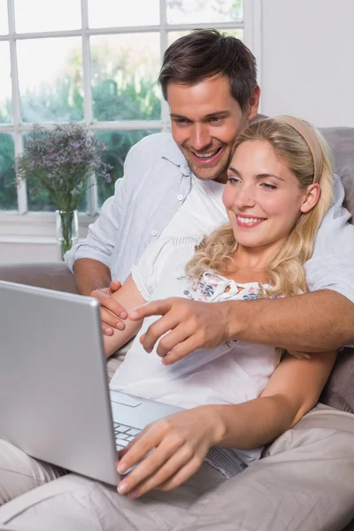 Relaxed casual couple using laptop in living room — Stock Photo, Image