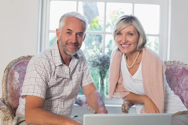 Lachende ouder paar laptop thuis gebruiken — Stockfoto