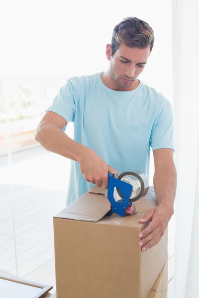 Hombre con cajas de cartón en casa nueva — Foto de Stock