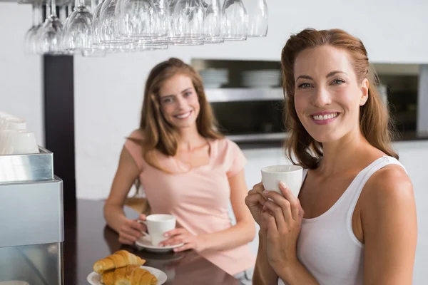 Amigos do sexo feminino tomando café no café — Fotografia de Stock