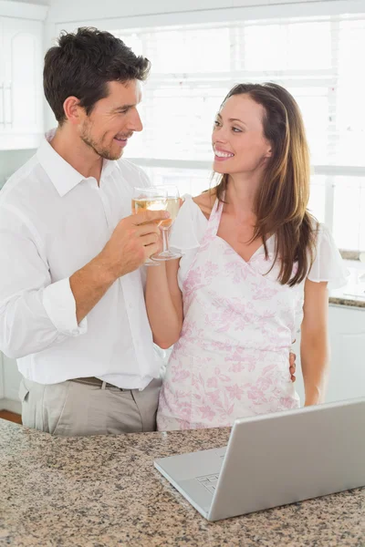 Loving couple toasting wine glasses in kitchen — Stock Photo, Image