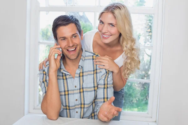 Happy man on call besides a beautiful woman — Stock Photo, Image