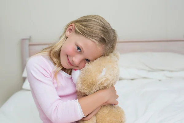 Jong meisje omarmen gevulde speelgoed in bed — Stockfoto