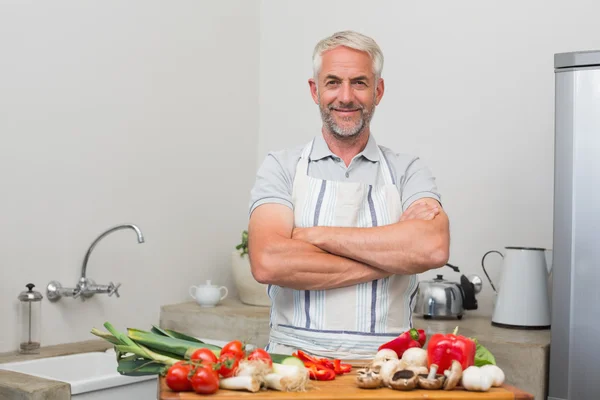 Portret van een volwassen man met groenten in de keuken — Stockfoto