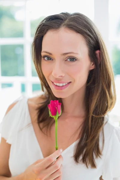 Piękna młoda kobieta z kwiatem w domu — Zdjęcie stockowe