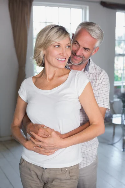 Volwassen man omhelst vrouw thuis — Stockfoto