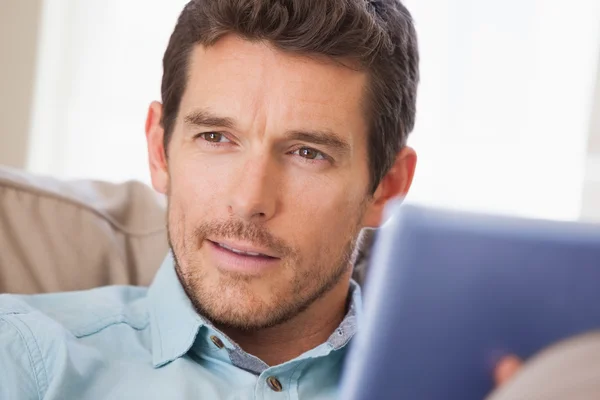 Homem com tablet digital olhando para casa — Fotografia de Stock