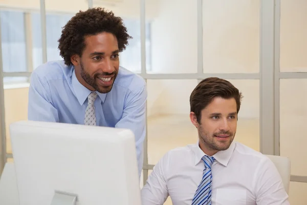 Businessmen with computer looking away in office — Stock Photo, Image