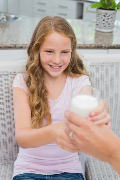 Happy young girl receiving a glass of milk — Stock Photo, Image