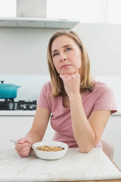 Tankeväckande kvinna med spannmål i köket — Stockfoto