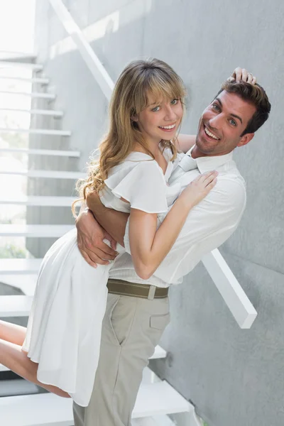 Loving young man carrying woman at home — Stock Photo, Image