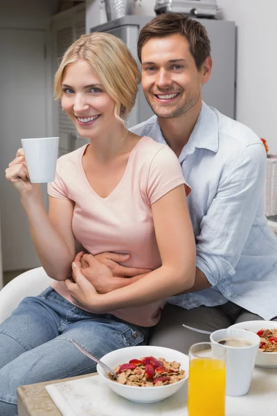Mann umarmt Frau am Frühstückstisch zu Hause — Stockfoto