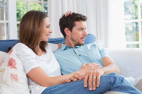 Любящие молодые пары сидят на диване — стоковое фото