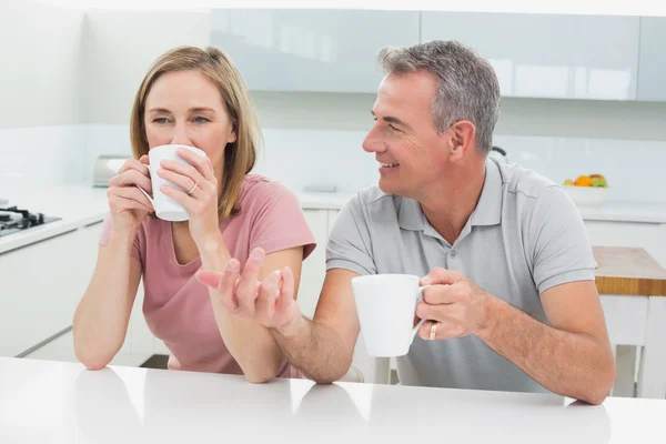 Coppia rilassata con tazze di caffè in cucina — Foto Stock