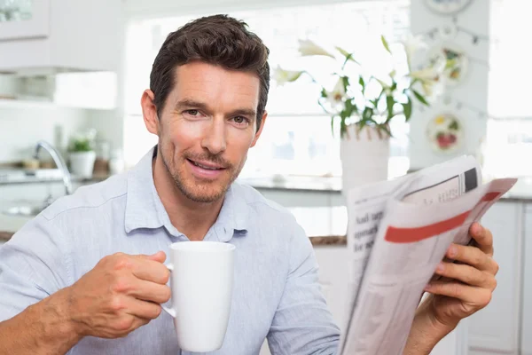 Uomo con giornale e tazza di caffè a casa — Foto Stock