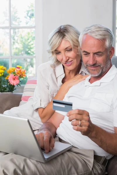 Gelukkige volwassen paar doen online winkelen thuis — Stockfoto