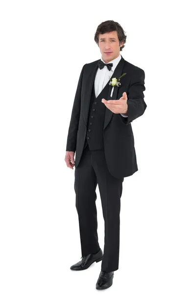 Groom in tuxedo offering hand — Stock Photo, Image