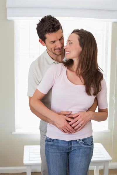 Loving man embracing woman from behind — Stock Photo, Image