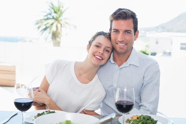 Casal amoroso com copos de vinho na mesa de almoço — Fotografia de Stock