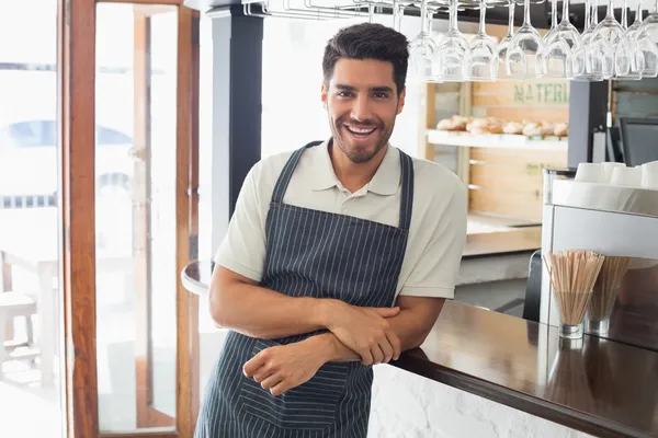 Портрет улыбающегося молодого официанта у стойки кафе — стоковое фото