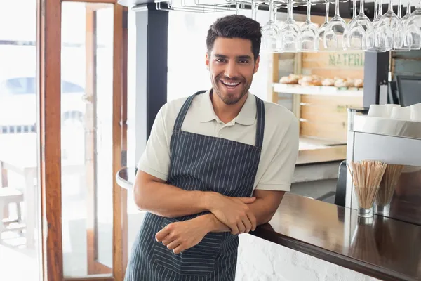 Retrato de um jovem garçom sorridente no balcão do café — Fotografia de Stock