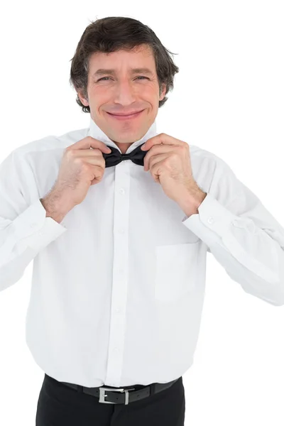 Smiling groom adjusting bow tie — Stock Photo, Image