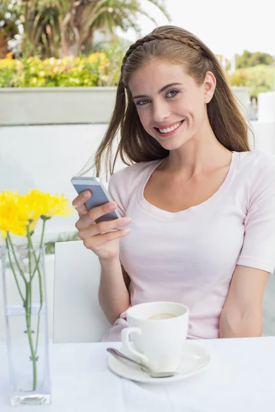 Kvinna med kaffe kopp textmeddelanden i café — Stockfoto