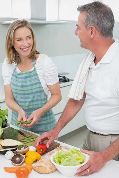 Pareja feliz preparando comida juntos en la cocina —  Fotos de Stock