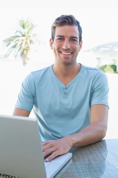 Uśmiechnięty mężczyzna młody za pomocą laptopa — Zdjęcie stockowe