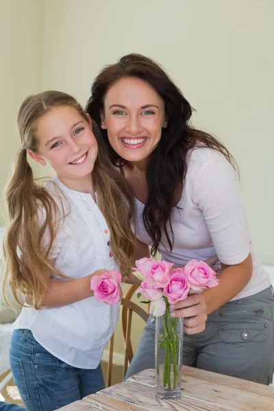 Mor och dotter arrangera blommor i vas — Stockfoto