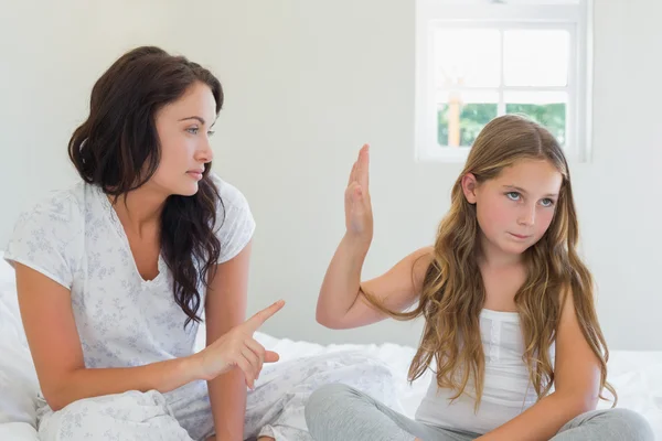 Girl showing stop gesture to angry mother in bed — Stock Photo, Image