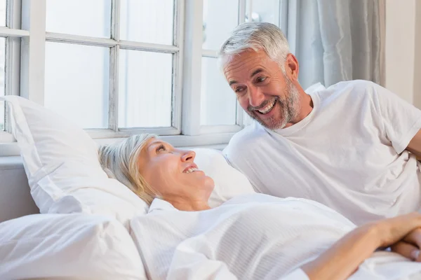 Lachende ontspannen ouder paar liggend in bed — Stockfoto