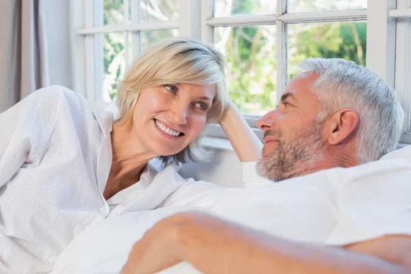 Lachende ontspannen ouder paar liggend in bed thuis — Stockfoto