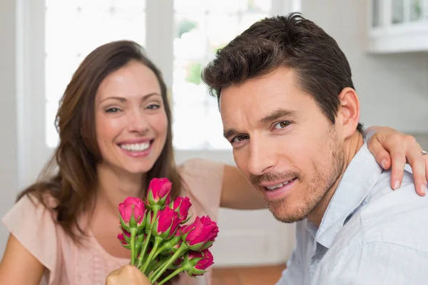 Nahaufnahme eines glücklichen Mannes und einer glücklichen Frau mit Blumen — Stockfoto