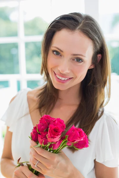 Vacker ung kvinna med blommor hemma — Stockfoto