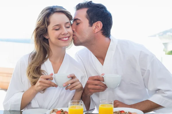 Man vrouw kussen aan ontbijttafel — Stockfoto