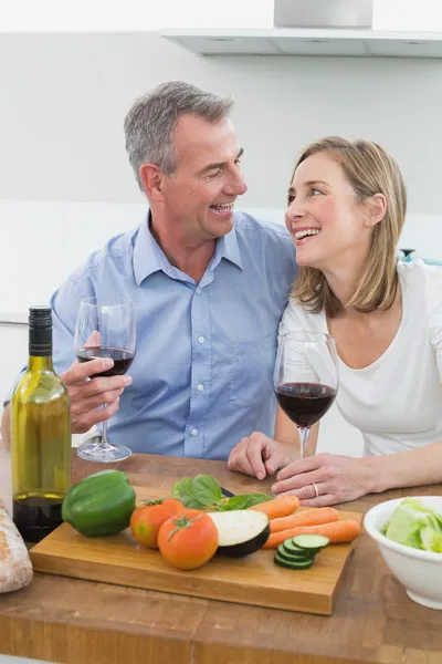 Весела пара з келихами для вина на кухні — стокове фото