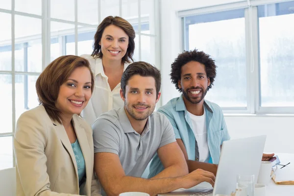 Glimlachende mensen uit het bedrijfsleven met behulp van laptop in vergadering — Stockfoto