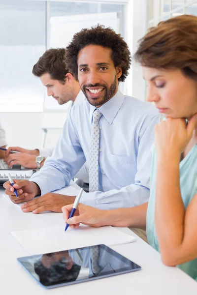 Glimlachend zakenman met collega's in de vergadering op kantoor — Stockfoto