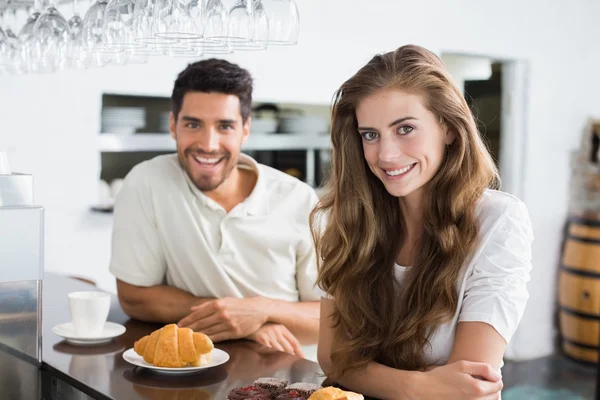 Smiling couple with coffee and croissant at coffee shop — Stock Photo, Image