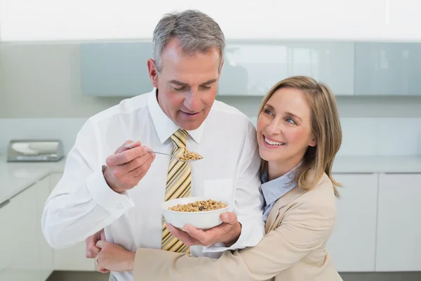 Donna che abbraccia l'uomo mentre fa colazione in cucina — Foto Stock