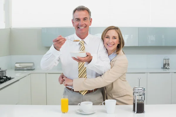 Donna che abbraccia l'uomo mentre fa colazione in cucina — Foto Stock