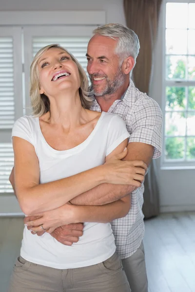 Mogen man omfamnar kvinnan bakifrån — Stockfoto