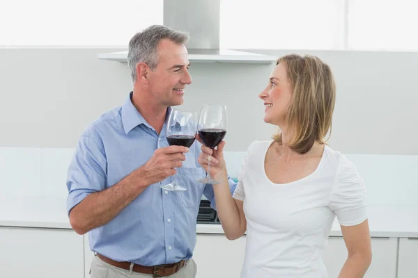 Verliefde paar roosteren wijn glazen in keuken — Stockfoto