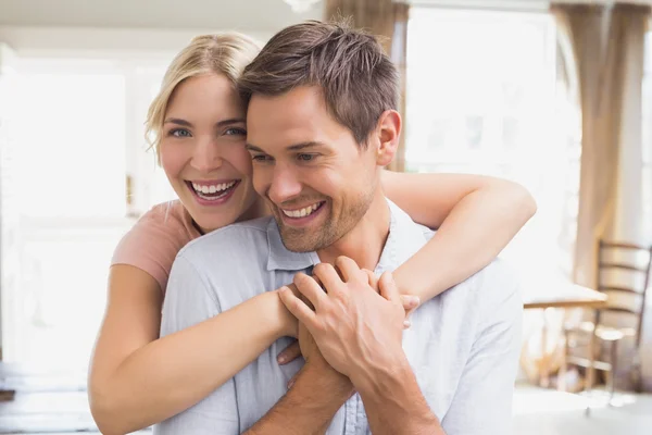 Mujer feliz abrazando al hombre desde atrás en casa — Foto de Stock