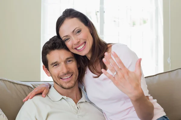 Mulher feliz mostrando anel de noivado além do homem — Fotografia de Stock
