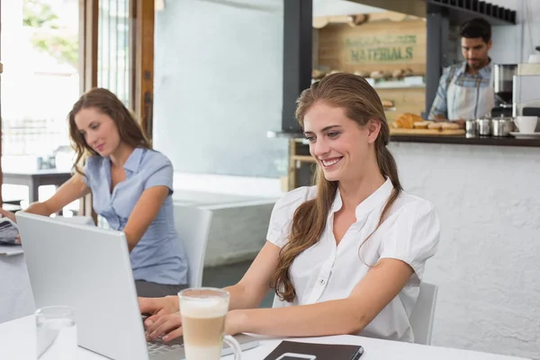 Donna che utilizza il computer portatile in caffetteria — Foto Stock