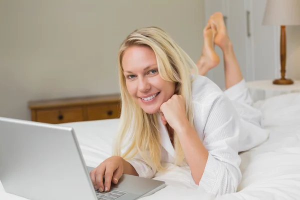 Kvinna som använder laptop i sängen — Stockfoto