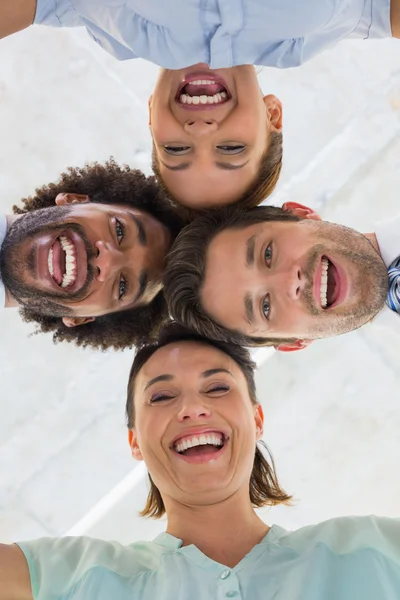 Business team with heads together forming huddle — Stock Photo, Image